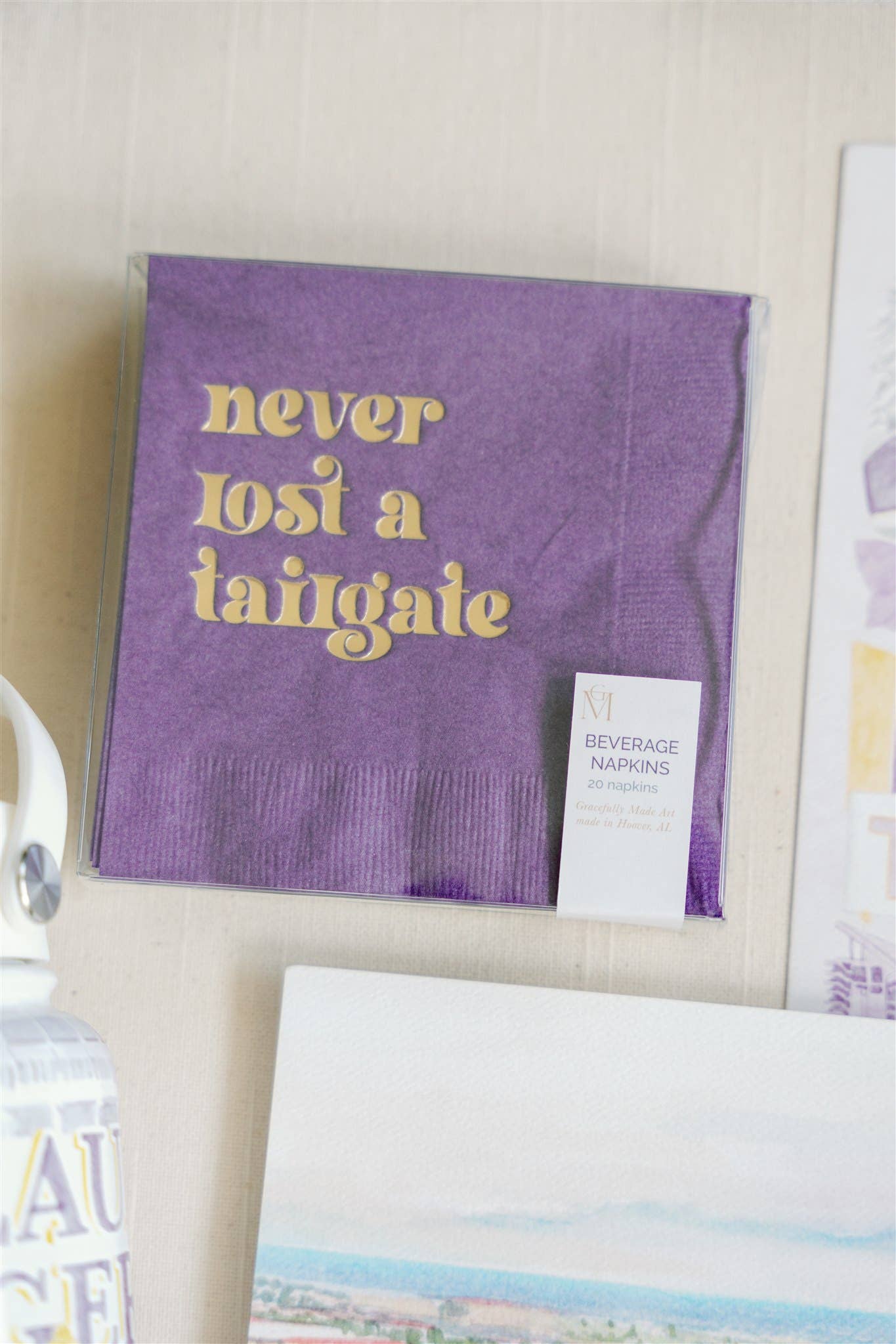 "Never Lost a Tailgate" gold foil + purple napkin pack