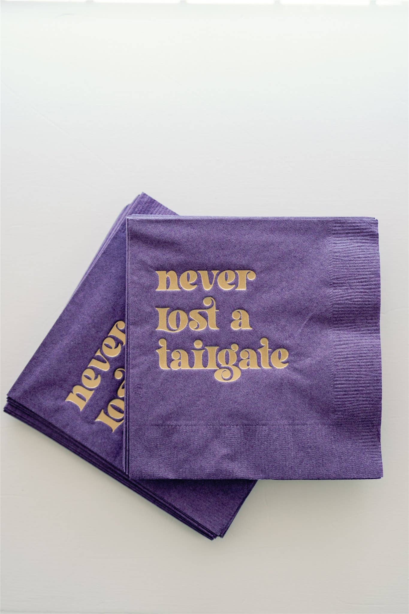 "Never Lost a Tailgate" gold foil + purple napkin pack