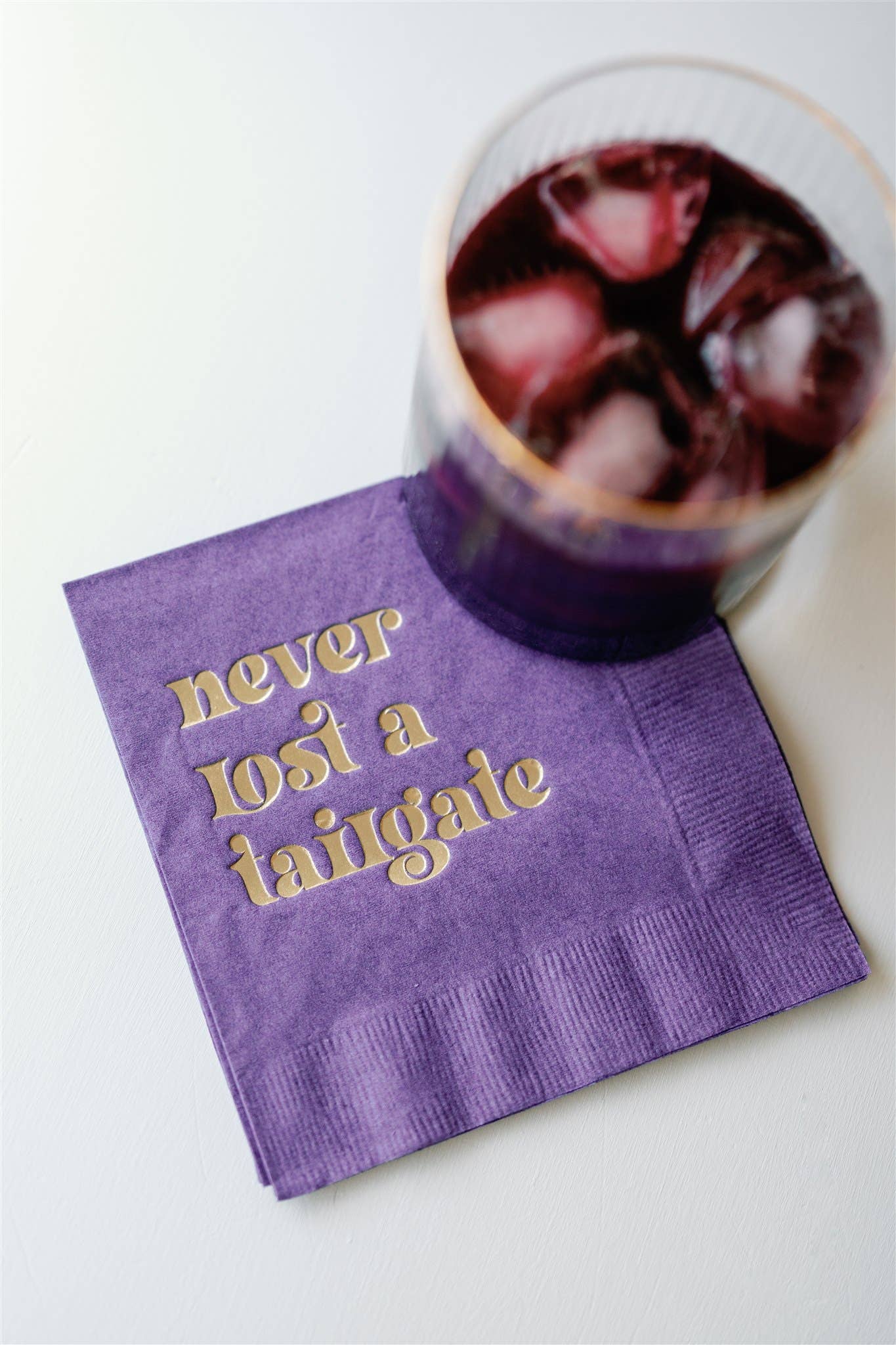 "Never Lost a Tailgate" gold foil + purple napkin pack